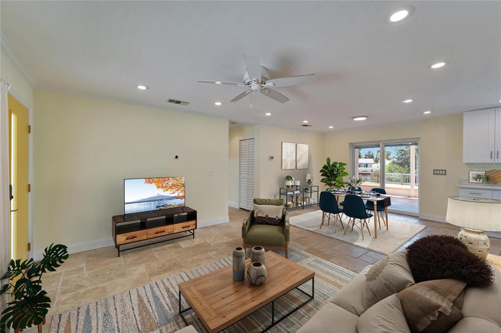 An open-concept living and dining area features tile flooring, a ceiling fan, and sliding doors — 8702 DRIFTWOOD DRIVE, TAMPA, FL