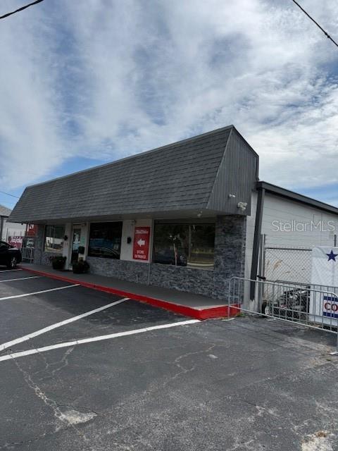 A commercial building with a gray shingled mansard roof and a stone-veneer facade — 9511 N NEBRASKA AVENUE, TAMPA, FL