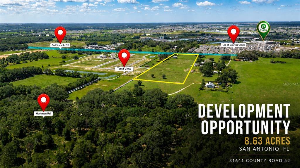 This aerial view shows an undeveloped plot of land highlighted in yellow near residential areas — 31641 COUNTY ROAD 52, SAN ANTONIO, FL