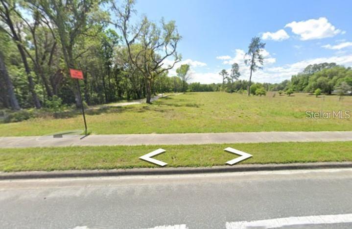 A vacant, grassy lot sits next to a sidewalk and a paved road — TBD W NEWBERRY ROAD, NEWBERRY, FL
