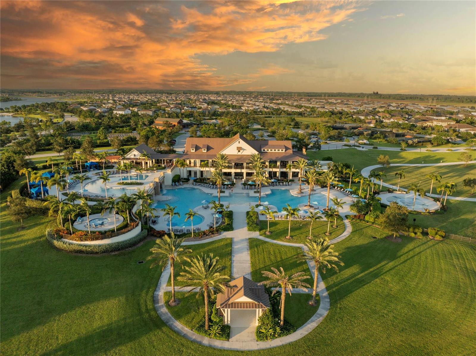 An aerial view of a large clubhouse with swimming pools, palm trees, and surrounding lawns — 19552 Broad Shore Walk, Loxahatchee FL 33470, LOXAHATCHEE, FL