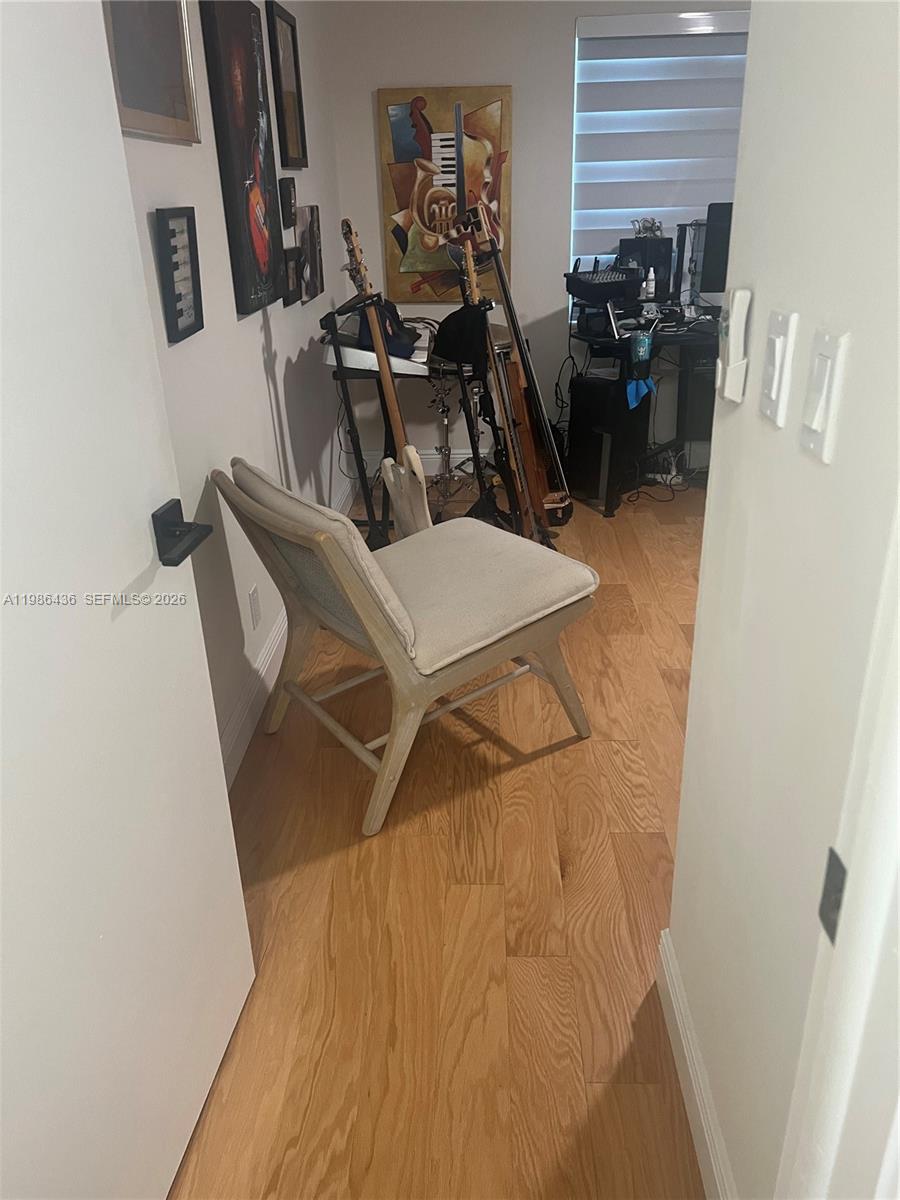 A small room features light wood flooring, a beige accent chair, and musical instruments — 8221 NW 14th St, Plantation FL 33322, PLANTATION, FL