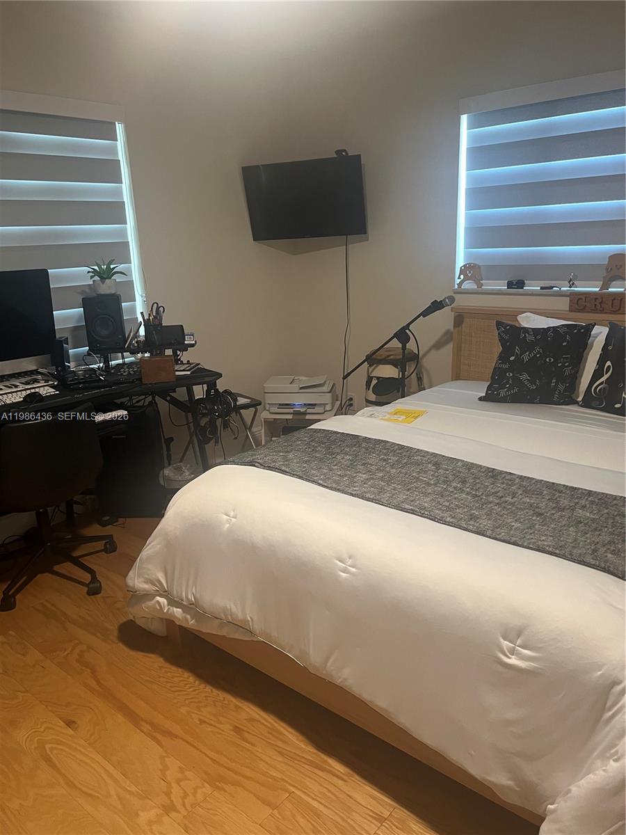A bedroom features a bed with white bedding, a desk with computer equipment, and two windows — 8221 NW 14th St, Plantation FL 33322, PLANTATION, FL