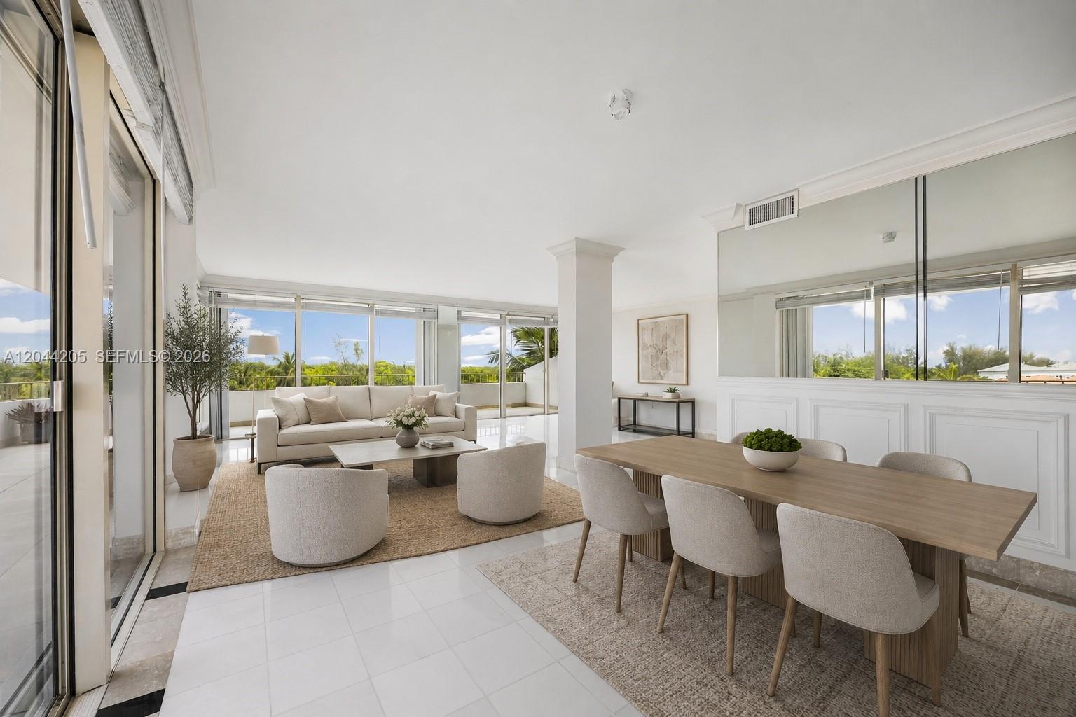 A bright living and dining area features white tile floors, floor-to-ceiling windows, and mirrored walls — 155 Ocean Lane Dr # 600, Key Biscayne FL 33149, KEY BISCAYNE, FL