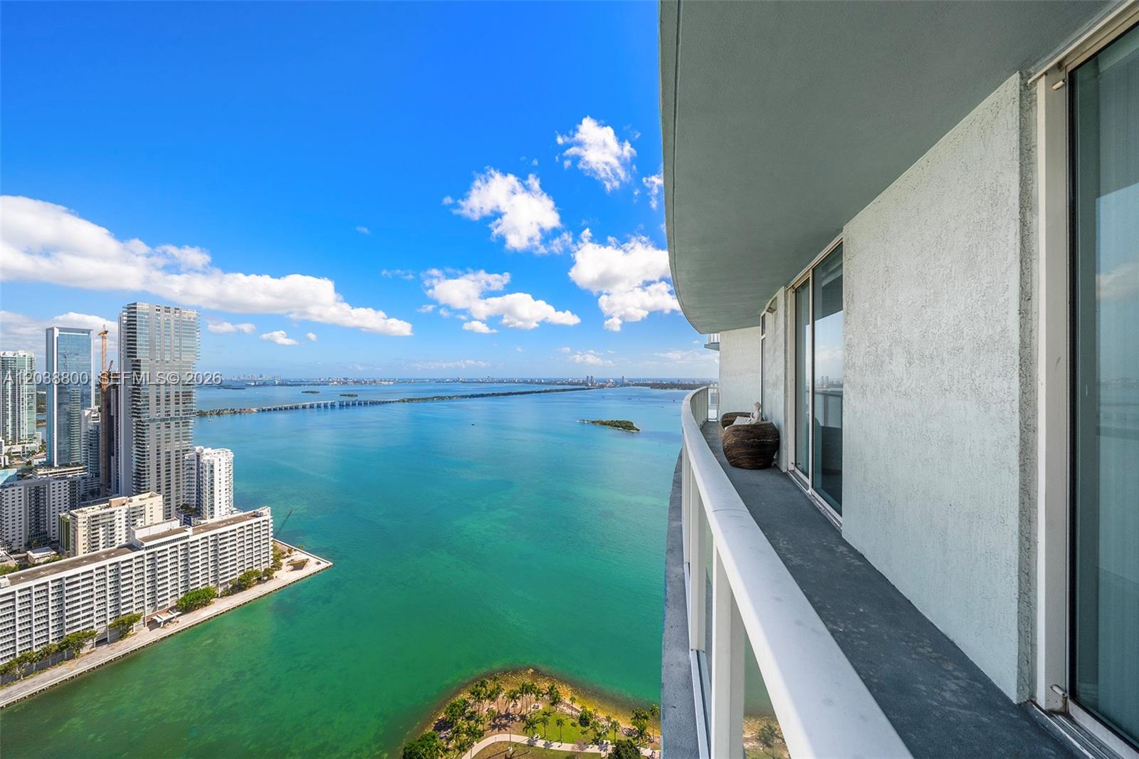 A high-rise balcony overlooks a bay with city buildings and a small island — 1900 N Bayshore Dr # 4504, Miami FL 33132, MIAMI, FL