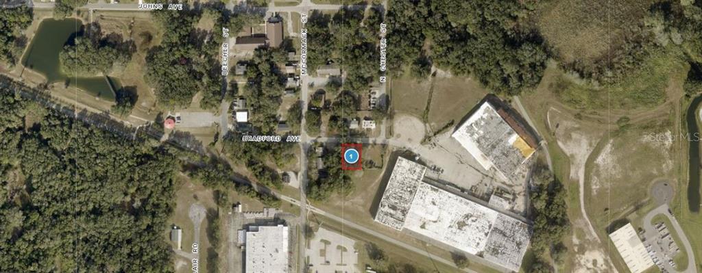 This is an aerial map showing a highlighted property lot located near several commercial buildings — 1903 BRADFORD AVENUE, LEESBURG, FL