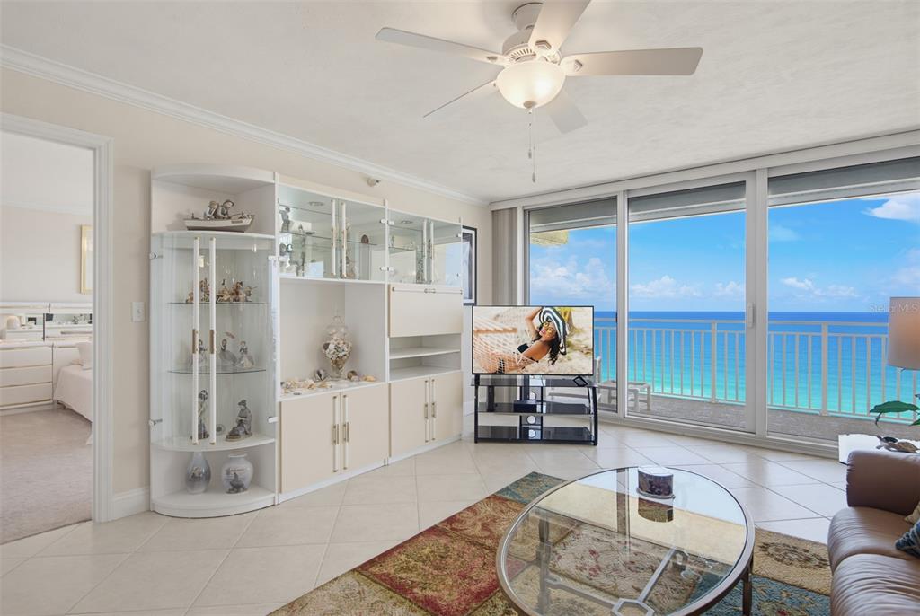 A living room features a white wall unit, a glass coffee table, and ocean views — 2545 S ATLANTIC AVENUE UNIT 1804, DAYTONA BEACH SHORES, FL