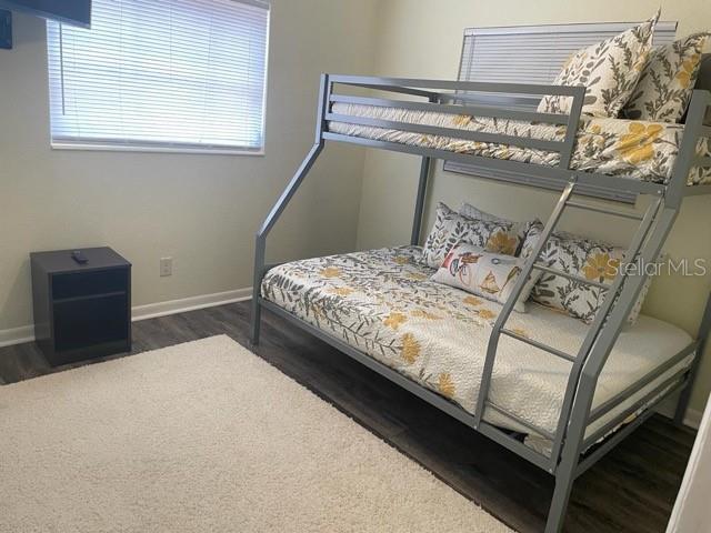 A bedroom features a metal bunk bed, a small black nightstand, and a white rug — 25 6TH AVENUE SE, LARGO, FL