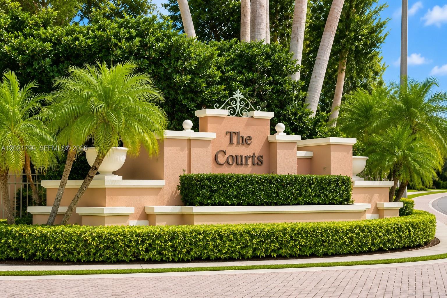 A beige stucco monument sign for The Courts stands surrounded by palm trees and landscaping — 6500 NW 114th Ave # 1021, Doral FL 33178, DORAL, FL