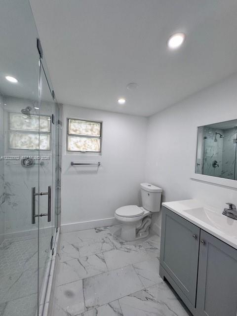 A modern bathroom features a glass-enclosed shower, a white toilet, and a grey vanity cabinet — 4783 NW Flagler Ter, Miami FL 33126, MIAMI, FL