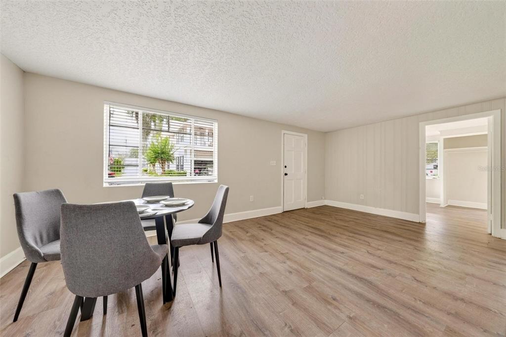A dining area with wood-look flooring, a window, and a doorway leading to another room — 1016 ATKINS PLACE, ORLANDO, FL
