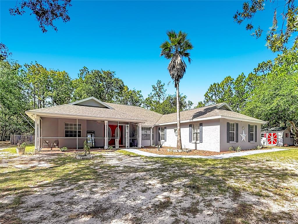 A single-story house with a screened porch, a palm tree, and a sandy yard — 13850 SW 71ST LANE, OCALA, FL