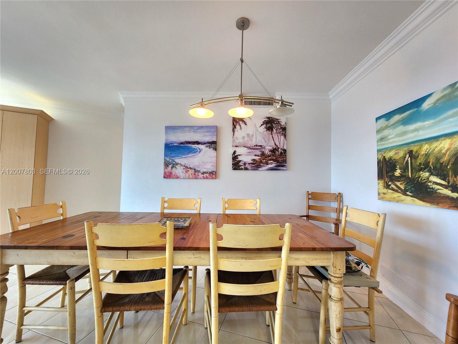 A dining room features a wooden table, six chairs, and three coastal-themed wall paintings — 3505 S Ocean Dr # 1103, Hollywood FL 33019, HOLLYWOOD, FL