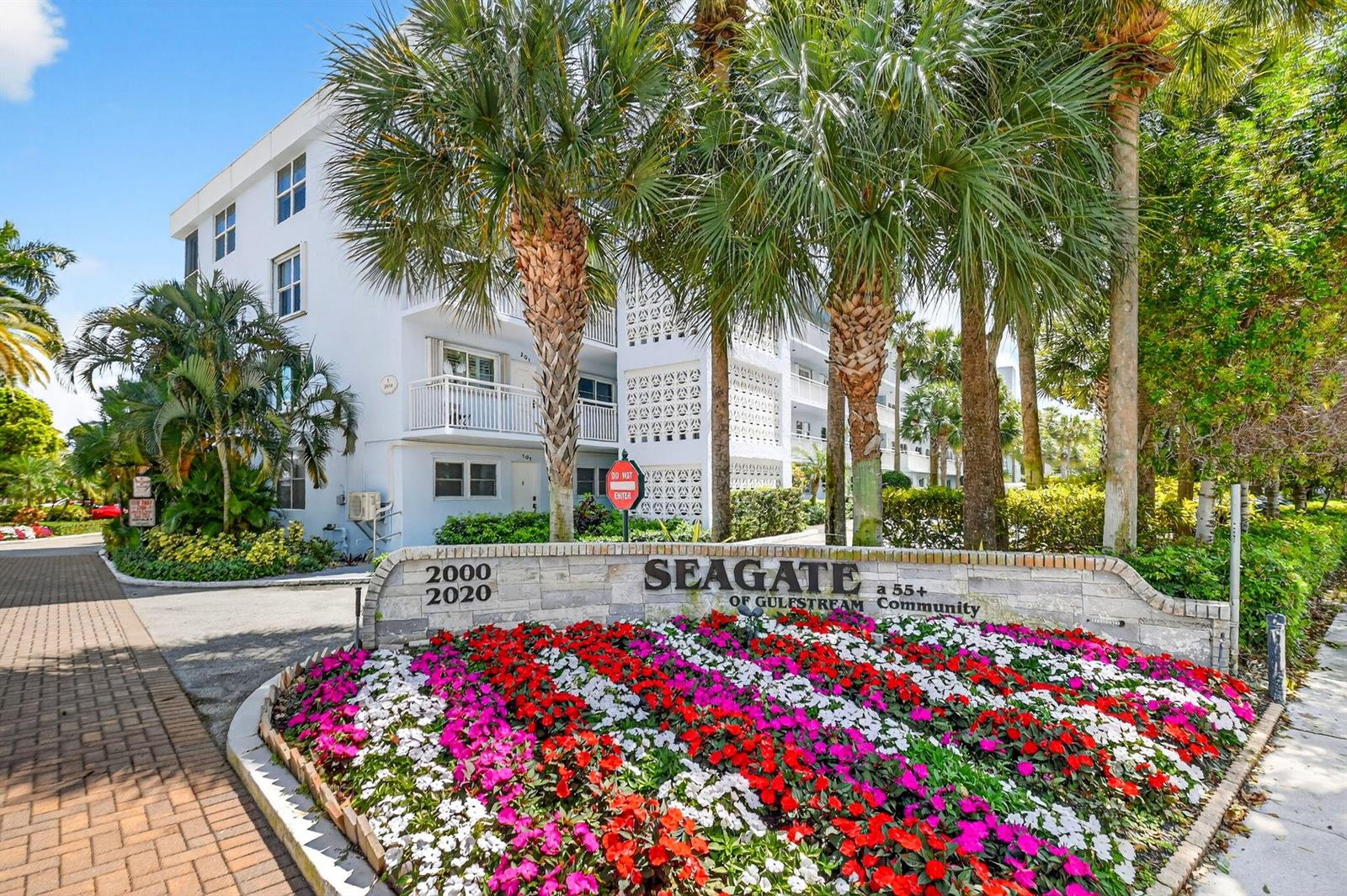 A stone sign for a 55+ community sits in front of a white multi-story building — 2010 S Federal Highway # 202, Boynton Beach FL 33435, BOYNTON BEACH, FL