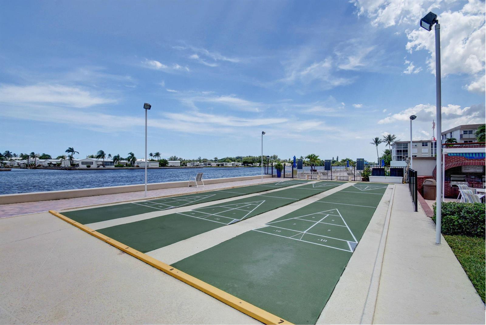 An outdoor shuffleboard court sits next to a waterfront walkway under a blue sky — 2010 S Federal Highway # 202, Boynton Beach FL 33435, BOYNTON BEACH, FL