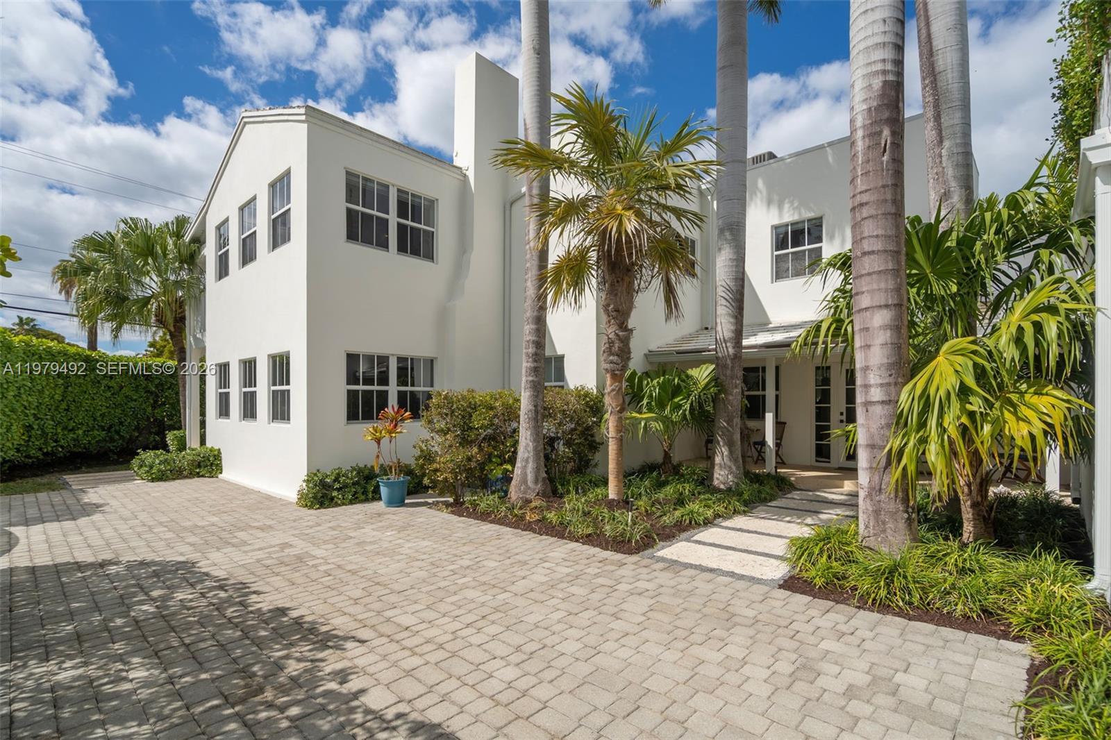 A two-story white stucco house features a paved driveway and several tall palm trees — 707 W 54th St, Miami Beach FL 33140, MIAMI BEACH, FL