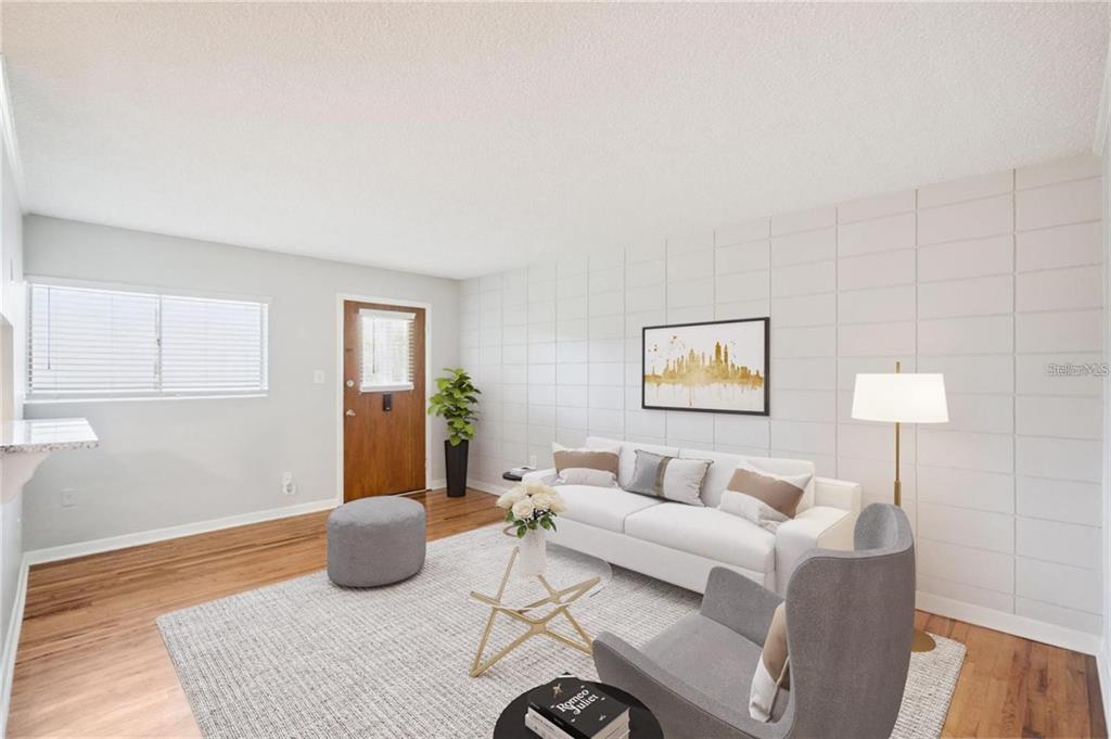 A living room features a white sofa, gray armchair, patterned rug, and a grid-paneled wall — 320 LAKEVIEW STREET UNIT 213, ORLANDO, FL