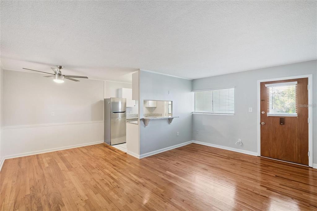 A living room with hardwood floors, a ceiling fan, and a pass-through to the kitchen — 320 LAKEVIEW STREET UNIT 213, ORLANDO, FL