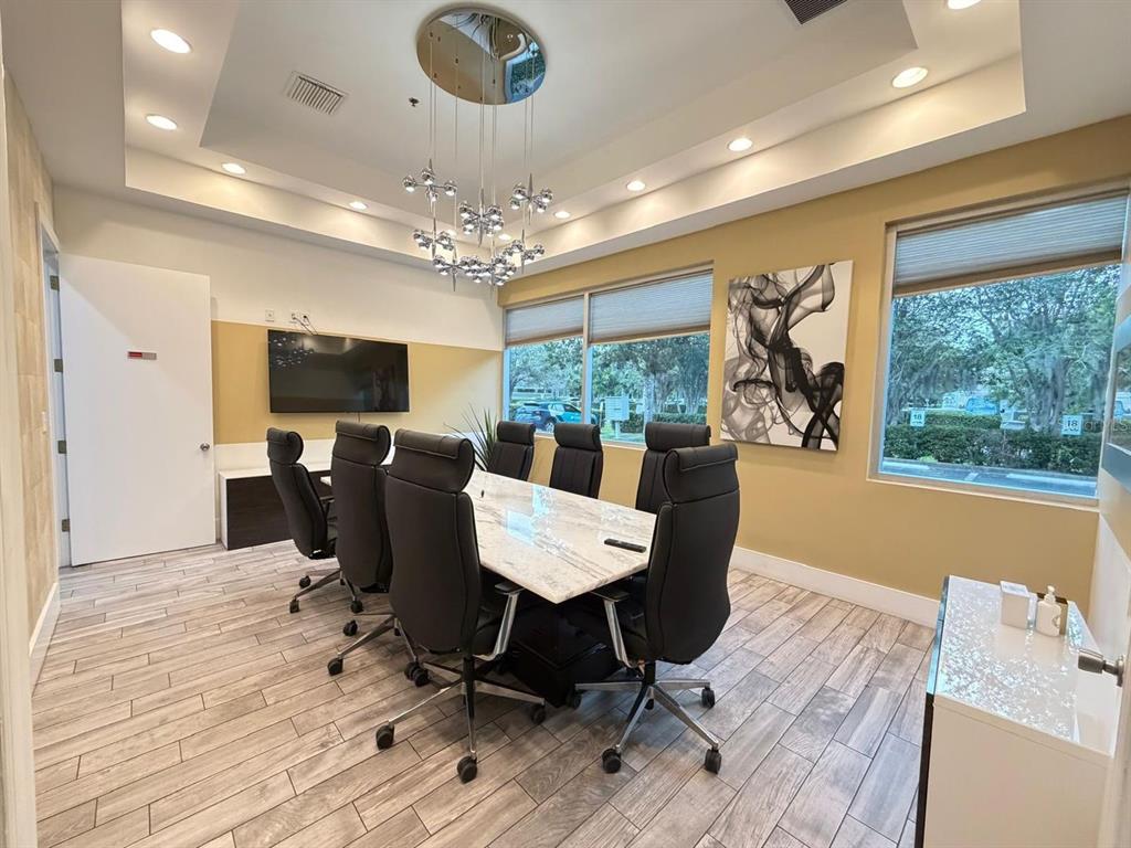 A conference room features a marble-topped table, black leather chairs, and a modern chandelier — 7901 KINGSPOINTE PARKWAY UNIT 16 and 17, ORLANDO, FL