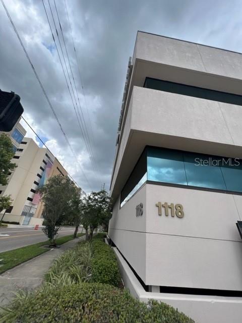 A low-angle exterior view of a modern multi-story office building with a light-colored facade — 1118 S ORANGE AVENUE UNIT 104, ORLANDO, FL