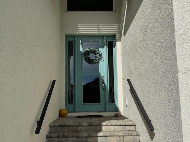 A teal front door with a wreath is centered at the top of stone steps — 6224 CHAMPIONS ROW STREET, BRADENTON, FL