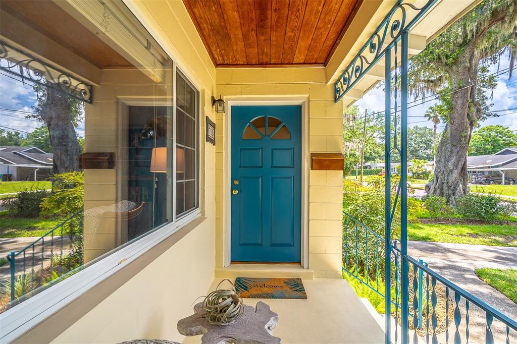 A front porch features a blue door, a wood-paneled ceiling, and decorative metal railings — 709 LAKE HIGHLAND DRIVE, ORLANDO, FL