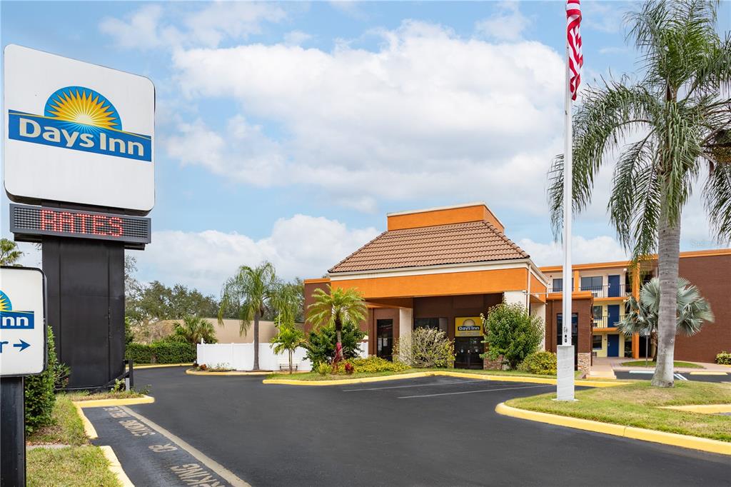The exterior of a Days Inn hotel features a parking lot, palm trees, and signage — 8245 S US-17-92 HIGHWAY, CASSELBERRY, FL