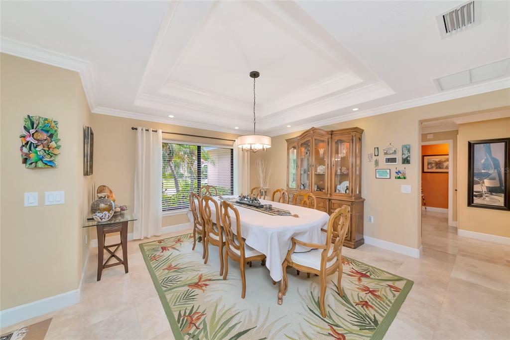 A dining room features a tray ceiling, a wooden hutch, and a floral area rug — 486 YACHT HARBOR DRIVE, OSPREY, FL