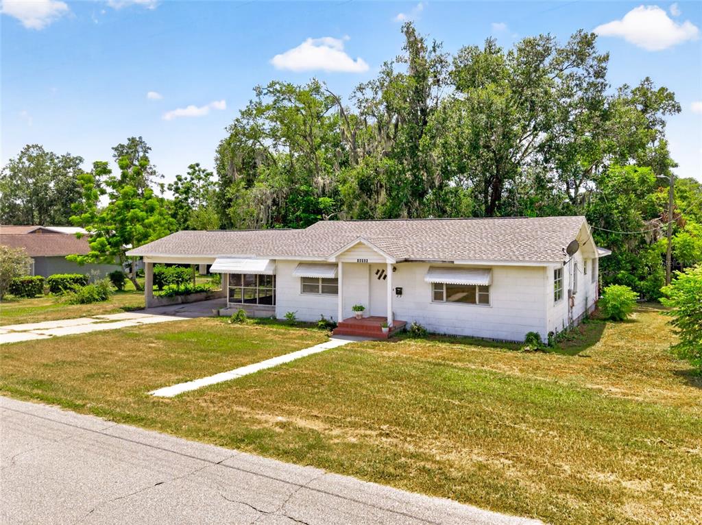 A single-story white house with a screened-in carport and a concrete driveway — 13725 10TH STREET, DADE CITY, FL