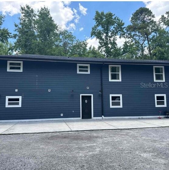 A two-story blue house with a dark front door and a concrete driveway — 9931 BERRY DEASE ROAD, ORLANDO, FL