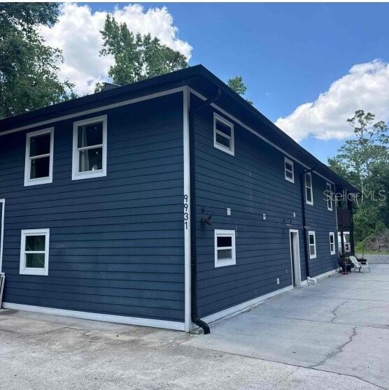 A two-story building with dark blue horizontal siding and white-trimmed windows — 9931 BERRY DEASE ROAD, ORLANDO, FL