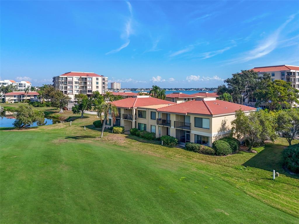 An aerial view of a multi-story apartment complex situated next to a golf course — 6105 PALMA DEL MAR BOULEVARD S UNIT 120, ST PETERSBURG, FL