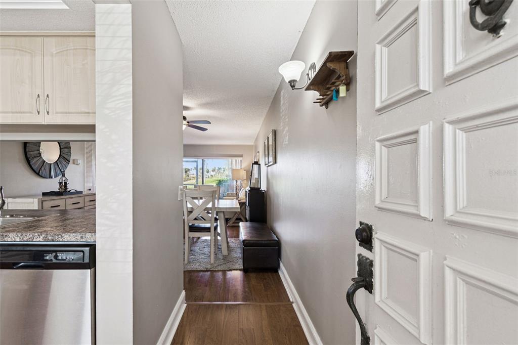 A view from an entryway looking into a dining area with wood flooring and cabinets — 6105 PALMA DEL MAR BOULEVARD S UNIT 120, ST PETERSBURG, FL