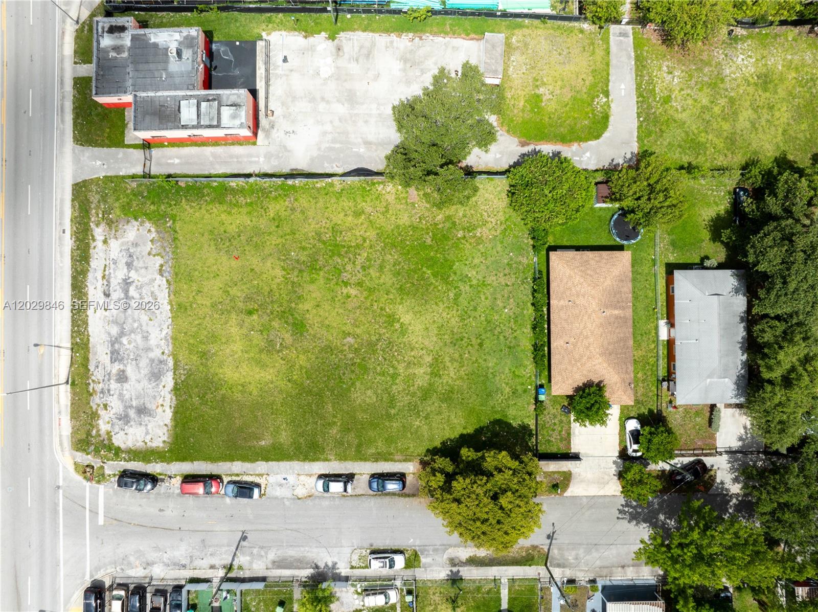 An aerial view shows a large vacant lot situated between a commercial building and residential houses — 7920 NW 11th Ave, Miami FL 33150, MIAMI, FL