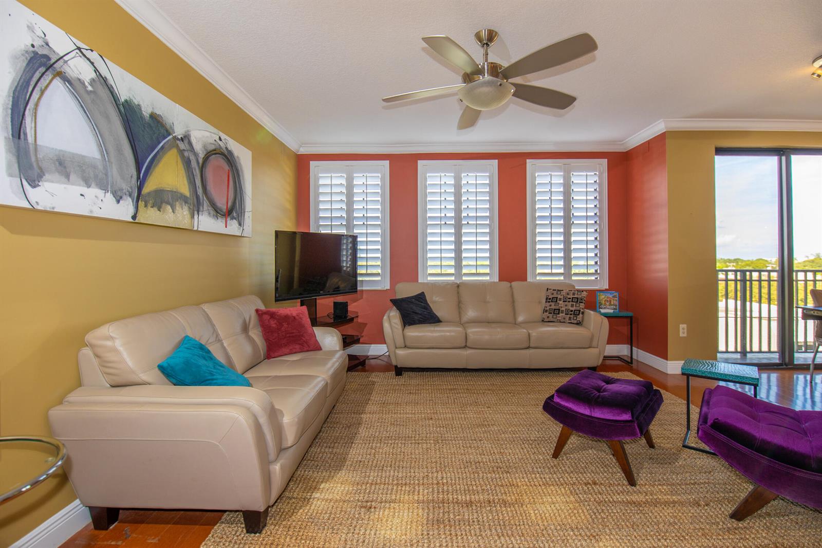 A living room features two beige leather sofas, purple accent furniture, and a ceiling fan — 511 Lucerne Avenue # 401, FL 33460, FL