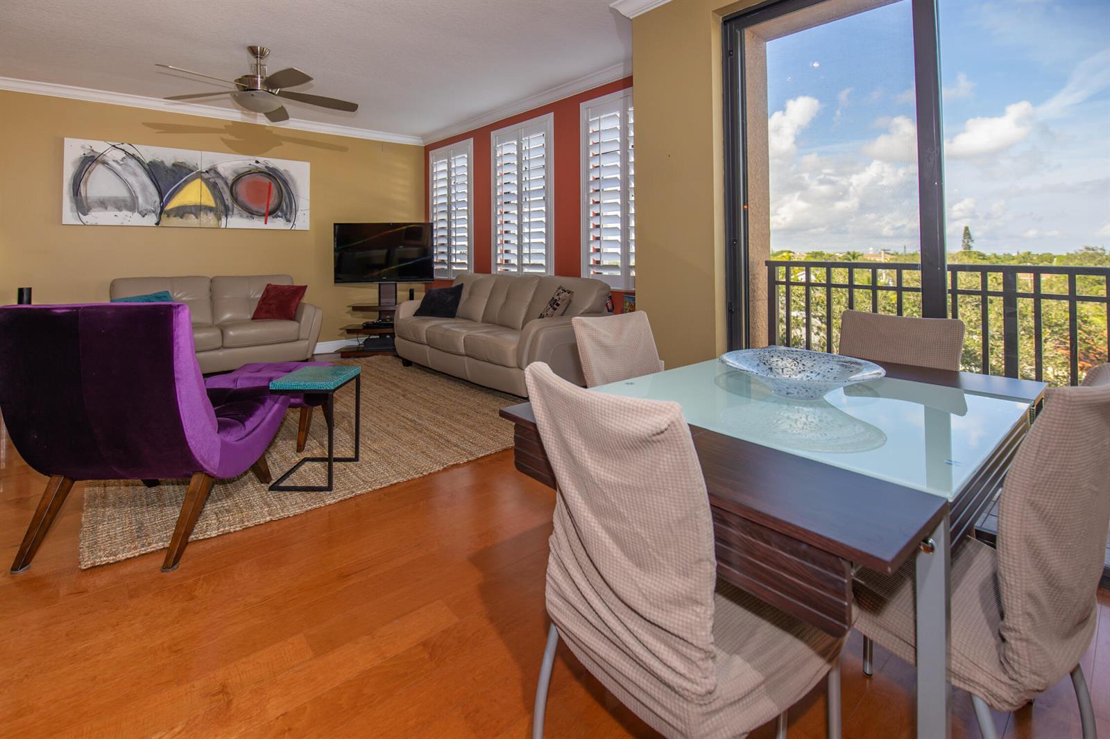 A living and dining area with hardwood floors, a purple chair, and a balcony view — 511 Lucerne Avenue # 401, FL 33460, FL