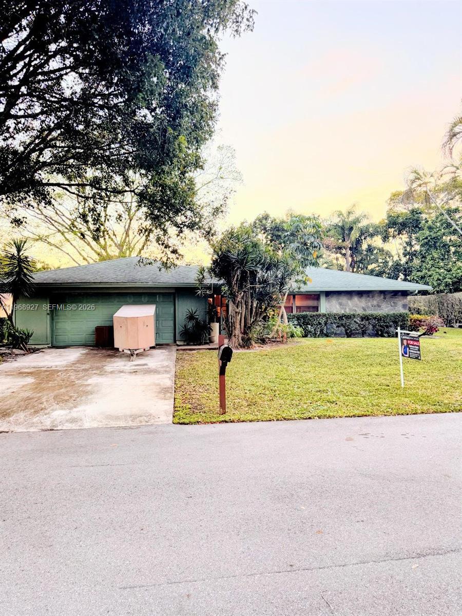 A single-story house with a green roof, stone facade, and a driveway with a trailer — 766 NW 24th Ave, Delray Beach FL 33445, DELRAY BEACH, FL