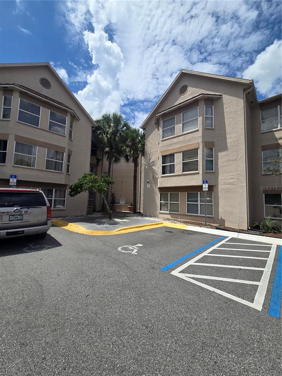 Exterior view of two multi-story apartment buildings with a paved parking lot in front — 3100 PARKWAY BOULEVARD UNIT 752, KISSIMMEE, FL