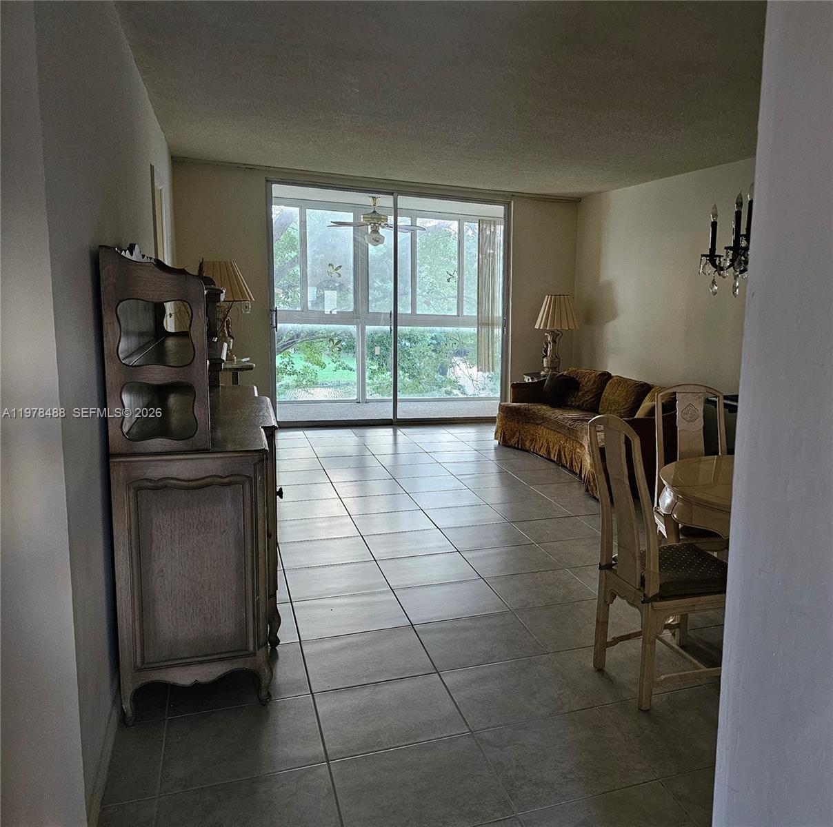 A living and dining area features tile flooring, a hutch, and a sliding glass door — 1103 NW 58th Ter # 321, Sunrise FL 33313, SUNRISE, FL