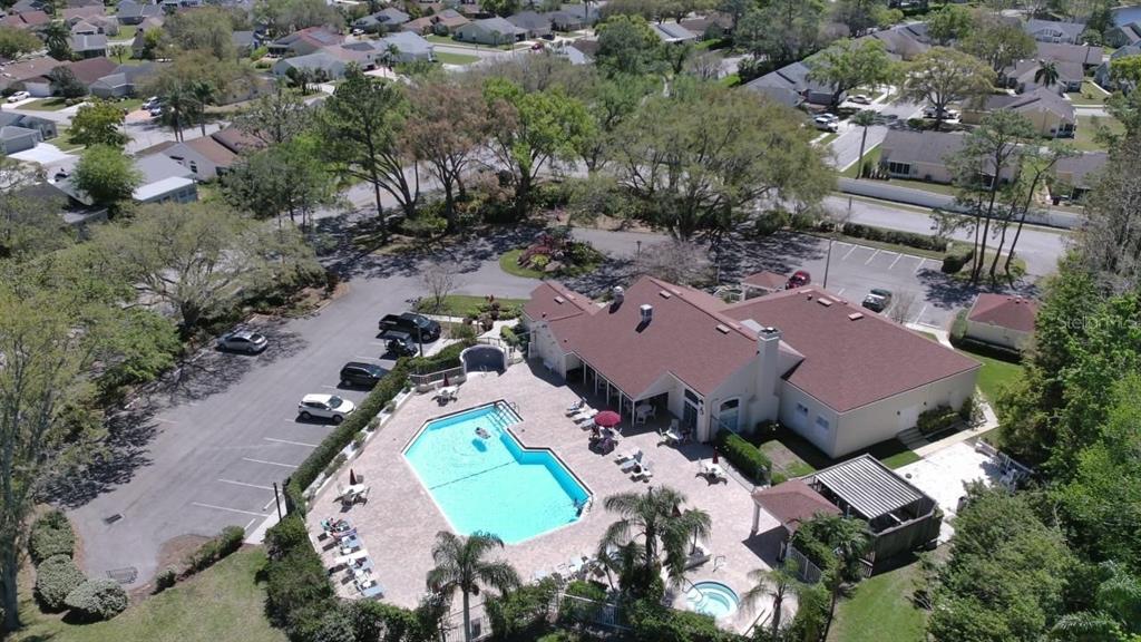 An aerial view of a community clubhouse featuring a swimming pool, hot tub, and parking — 4429 WHITTON WAY, NEW PORT RICHEY, FL