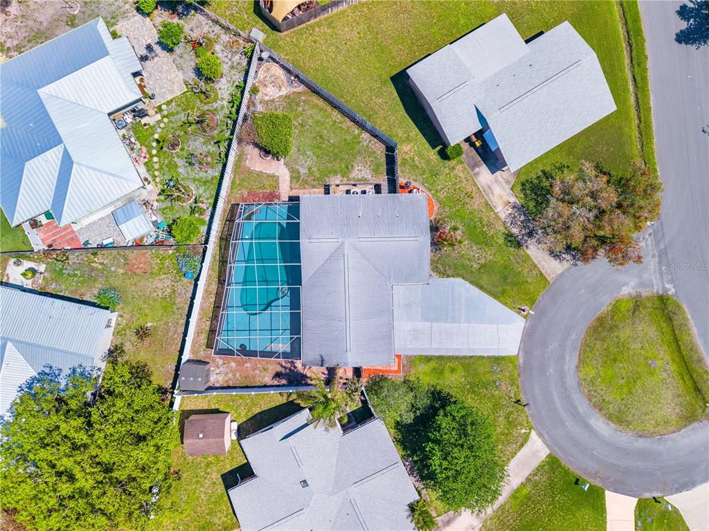 An aerial view shows a house with a screened-in pool and a fenced backyard — 683 JOHN HANCOCK LANE, WEST MELBOURNE, FL