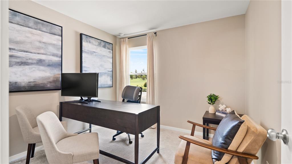 A home office features a dark wood desk, two chairs, and two large abstract paintings — 463 ARTEMIS STREET, LAKE WALES, FL