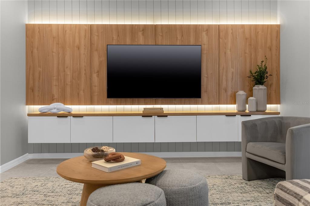 A modern living room features a wall-mounted television, wood paneling, and a floating white cabinet — 4358 LANA AVENUE, DAVENPORT, FL