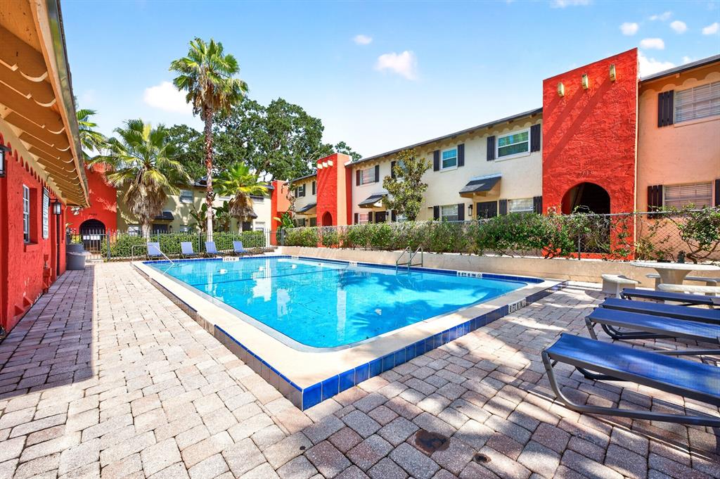A swimming pool sits on a brick patio in front of a two-story apartment building — 2423 E CENTRAL BOULEVARD UNIT 1, ORLANDO, FL