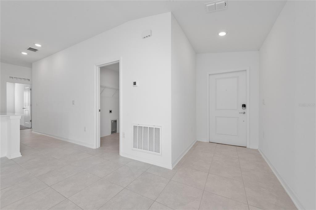 An interior view of an entryway with white walls, tile flooring, and a closet door — 338 RUSTIC RAIL DRIVE, LAKE WALES, FL