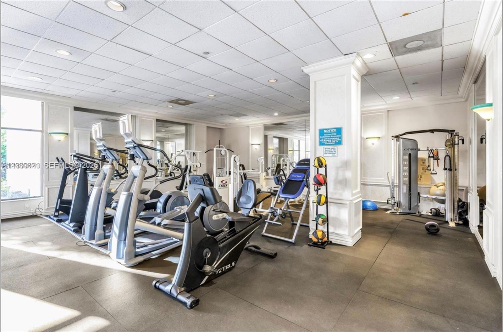 A bright living room features light tile floors, a sofa, an armchair, and a balcony — 5700 Collins Ave # 3N, Miami Beach FL 33140, MIAMI BEACH, FL