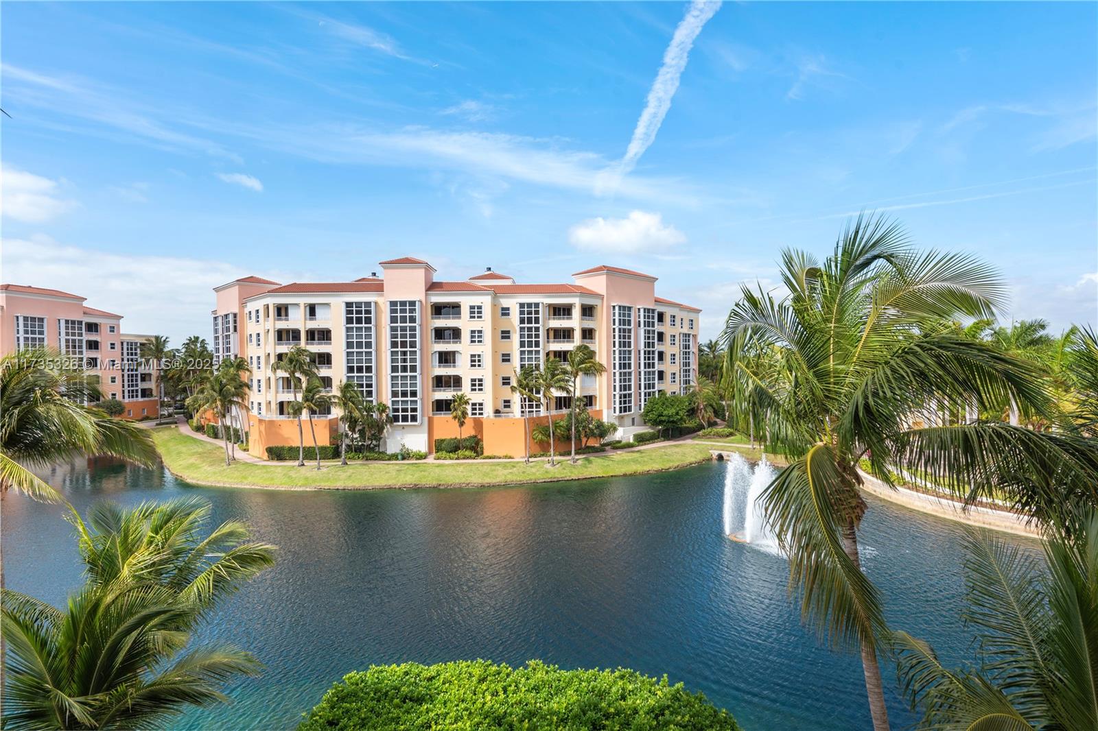 A multi-story apartment building sits beside a lake with a fountain and palm trees — 705 Crandon Blvd # 405, Key Biscayne FL 33149, KEY BISCAYNE, FL