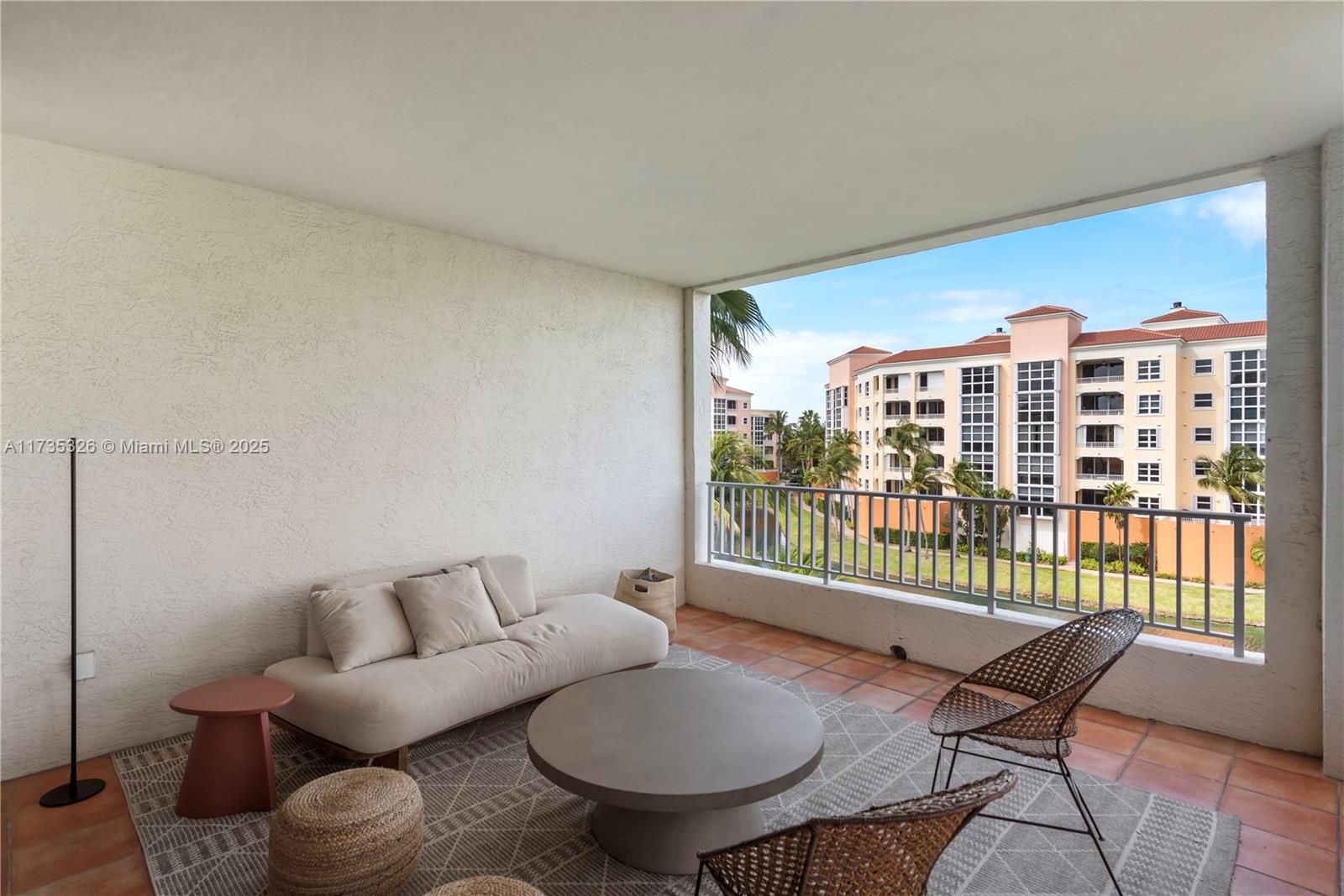 A covered balcony features a sofa, round coffee table, two chairs, and a metal railing — 705 Crandon Blvd # 405, Key Biscayne FL 33149, KEY BISCAYNE, FL