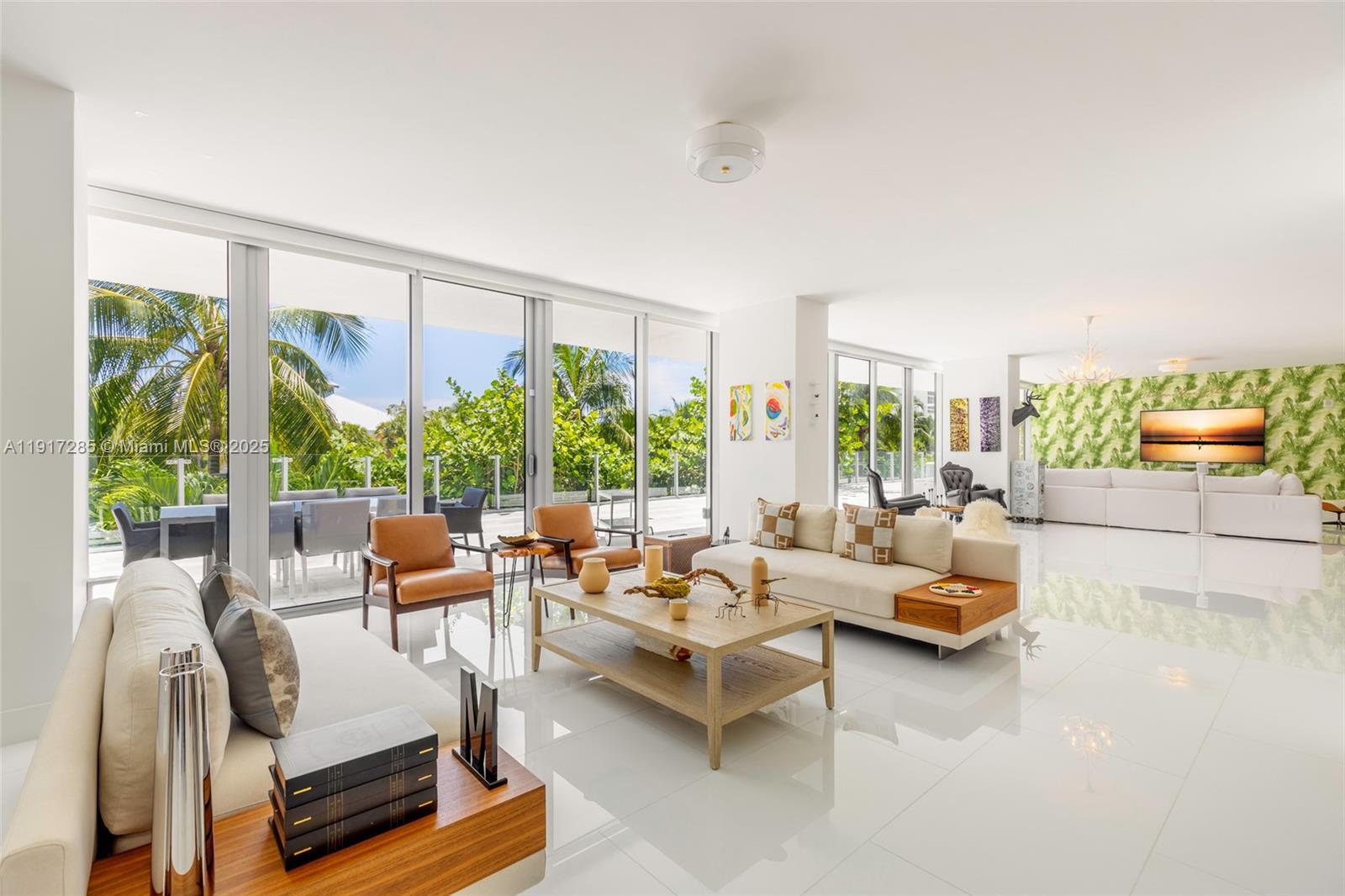 A bright, open-concept living room features white tile floors, modern furniture, and floor-to-ceiling glass walls — 1 Collins Ave # 207, Miami Beach FL 33139, MIAMI BEACH, FL