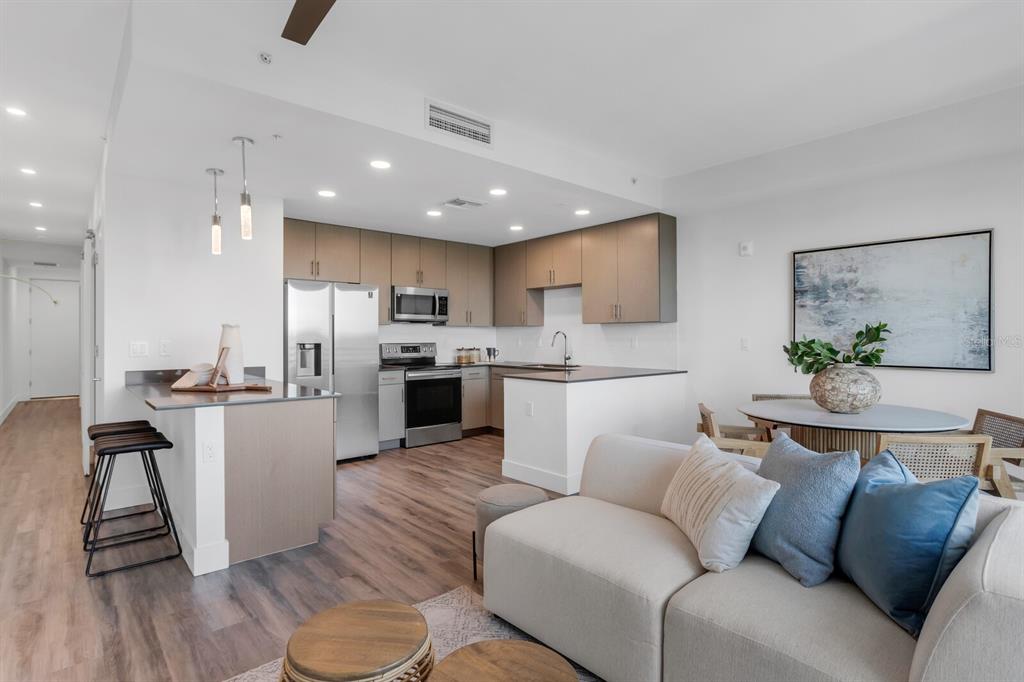 An open-concept kitchen with stainless steel appliances and a living area with a sectional sofa — 1709 N TAMIAMI TRAIL UNIT 503, SARASOTA, FL